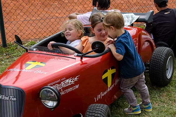 's Münchner Herz Familiensommerfest 2023 – Kinder inspizieren den Hot Rod